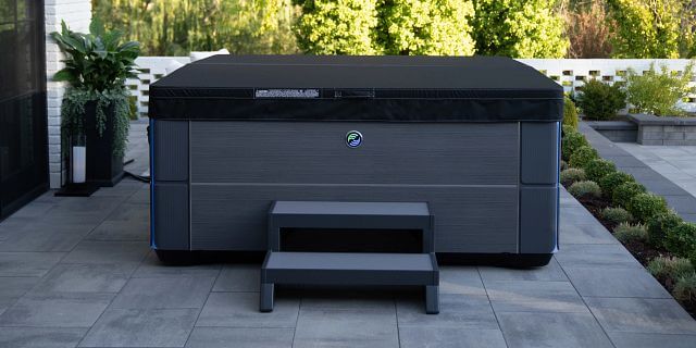 Hot Spring Spa's Aria hot tub is shown in charcoal color with a black Weather Pro™  Cover.