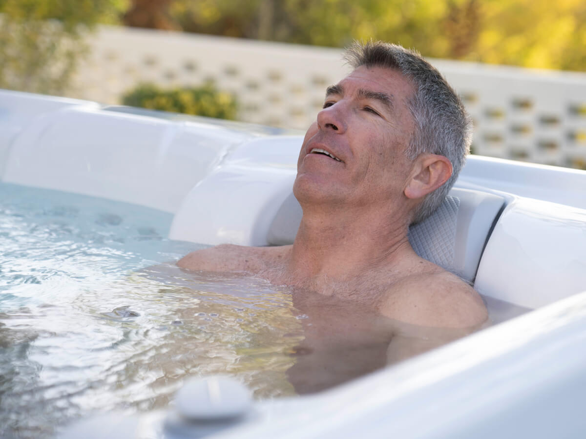 A man relaxes in a hot tub after an exercise session.