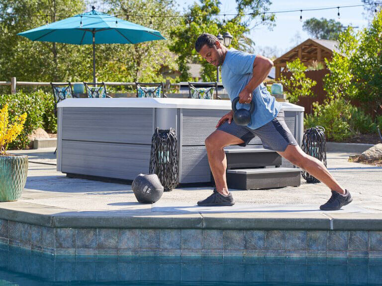 A man completes an intense workout session and prepares to jump into a hot tub to soothe sore muscles.